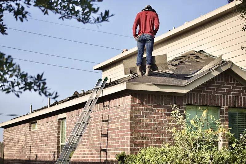 Professional roofer working on a residential roof in Cornell